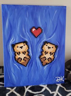 two pixel art pieces are displayed on a blue background with black and white patterns, one is holding a red heart