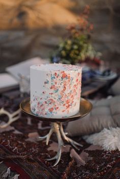 a white cake with sprinkles sitting on top of a table