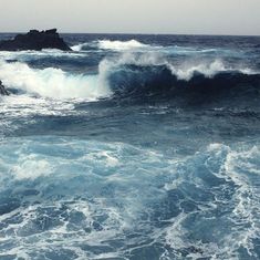 the waves are crashing on the rocks in the ocean