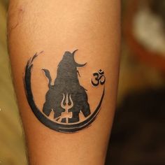 a tattoo on the leg of a person with an animal and omen symbol in it