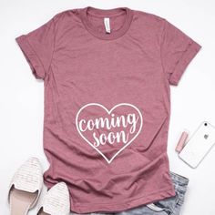 a t - shirt with the words coming soon written on it next to some shoes