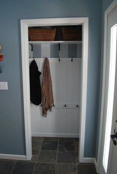 a coat rack with two coats hanging from it's hooks in a blue room