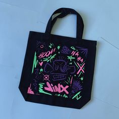 a black tote bag with graffiti on it