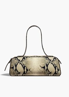 A refined and elongated silhouette that unites decisive lines with soft curves. Topped by sleek, doubled straps and a custom zipper. Suede-lined interior. Khaite Bag, Paris And London, Cream Bags, Fall Handbags, Leather Outerwear, 2024 Style, Womens Designer Handbags, Denim Shoes, Bag Trends