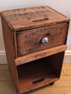 an old wooden box sitting on top of a hard wood floor next to a wall