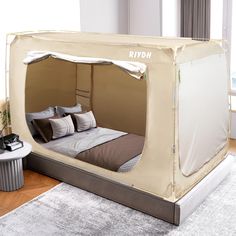 a room with a bed that has a canopy over it and pillows on the floor