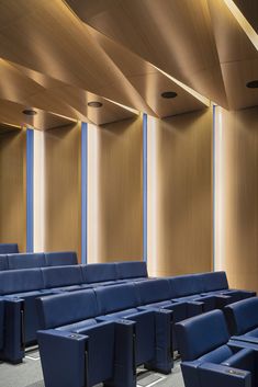 rows of blue seats in front of wooden walls and ceiling with light coming from the windows