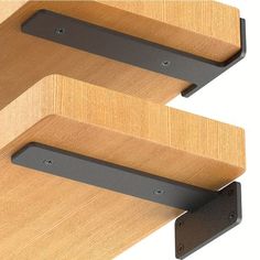 two metal brackets on the side of a wooden wall mounted shelf with wood veneers