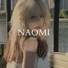 a woman with long blonde hair standing in front of water and the words naomi