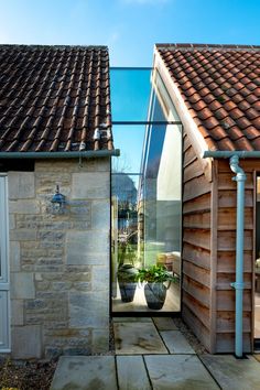 an outside view of a house that is made out of wood and stone, with a glass door leading into the back yard