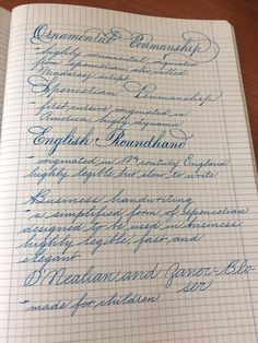 the writing is lined up on top of an open notebook, with blue cursive ink