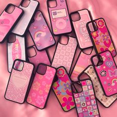 a bunch of cell phones that are on a pink surface with flowers and hearts in them