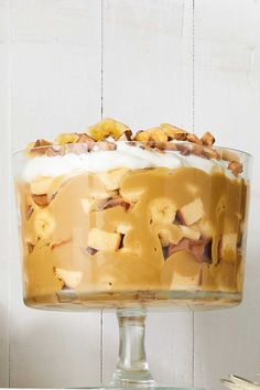 a banana trifle in a glass dish on top of a wooden table with the title butterscotch - banana trifle