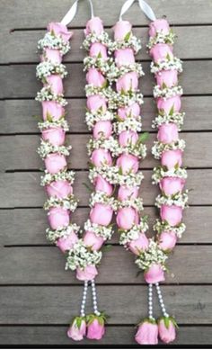 pink roses and baby's breath flowers are arranged in the shape of letters n