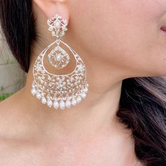 Indulge in the allure of heritage and sophistication with our sterling silver chandbali earrings, featuring delicate floral motifs and exquisite pearls. Crafted to perfection, these earrings seamlessly blend tradition with modern elegance, adding a touch of opulence to any ensemble. Elevate your style with timeless grace and charm, as each pair whispers tales of luxury and refinement.