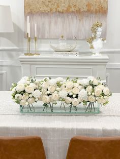 a table with white flowers and candles on it