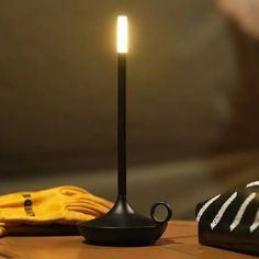 a candle that is sitting on top of a table next to a hat and glove