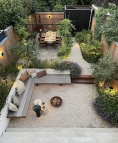 an aerial view of a backyard with seating and table in the center, surrounded by trees