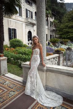 a woman in a wedding dress standing on a balcony