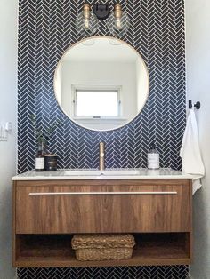 a bathroom sink with a mirror above it and a towel on the shelf next to it