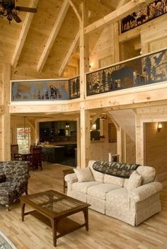 a large living room with high ceilings and wooden flooring on the second floor is decorated in rustic style