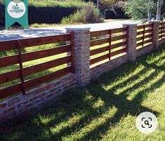 a wooden fence is next to a brick wall