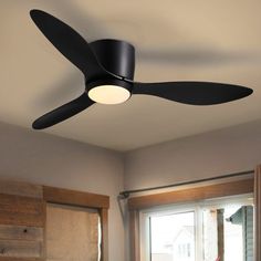 a black ceiling fan in a bedroom next to a window