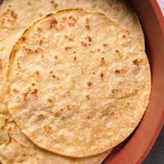 three tortillas sitting in a bowl on top of a table