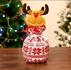 a stuffed reindeer head sitting on top of a red and white christmas ornament