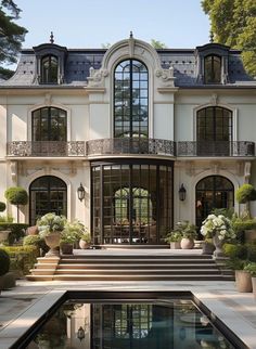 a large white house with lots of windows and plants in front of the pool area