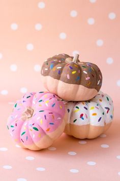 three donuts with sprinkles are stacked on top of each other in front of a sign that says click here for more