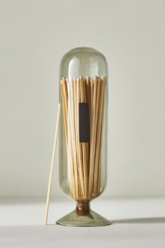 a glass jar filled with wooden sticks on top of a table