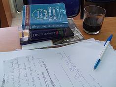 a stack of books sitting on top of a table next to a glass of water