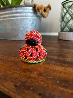 a small toy sitting on top of a wooden table next to a potted plant