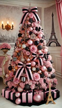 a pink and black christmas tree decorated with roses, ornaments and baubles in front of the eiffel tower