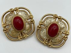 Huge Etruscan Statement Earrings with Red Cabochon and Enamel Finish -Signed Monet -Gold tone finish with creamy enamel overlay and accent by a large red cabochon -Openwork Etruscan motif -Excellent vintage condition -Each measures approximately 1 5/16" long x 1 1/4" wide******************************************************************************************************************************************************************************************All jewelry purchases are tastefully wrapp Vintage Cabochon Clip-on Earrings As Gift, Red Enamel Clip-on Jewelry, Red Enamel Clip-on Earrings, Vintage Red Enamel Earrings, Vintage Gold Cabochon Clip-on Earrings, Red Enamel Vintage Earrings, Luxury Vintage Cabochon Clip-on Earrings, Vintage Orange Clip-on Earrings, Triple Ring