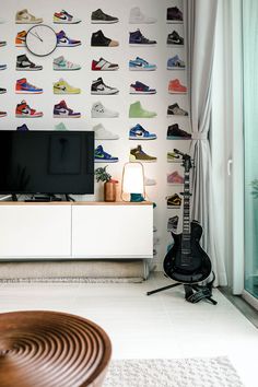 a living room with a television and various shoes on the wall