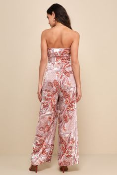 Bask in the sun in perfect style when you're wearing the Lulus Aesthetic Perfection Ivory Paisley Tie-Front Strapless Jumpsuit! Sleek woven satin boasts a Boho-chic, rust red-toned paisley print as it shapes a strapless, tie-front bodice with a notched sweetheart neckline (with hidden V-bar support and no-slip strips). Fitted waist tops wide legs that finish at full-length hems. Hidden zipper/clasp at back. Fit: This garment fits true to size. Length: Floor length. Size medium measures 53.25" fr Elegant Strapless Jumpsuit For Beach, Elegant Strapless One-piece Jumpsuit For Summer, Chic Strapless Jumpsuits And Rompers With Floral Print, Floral Print Strapless Jumpsuit For Summer, Chic Strapless Floral Print Jumpsuits And Rompers, Chic Floral Print Strapless Jumpsuit For Summer, White Bandeau Strapless Jumpsuit For Summer, Chic Strapless Floral Print Jumpsuit For Summer, Strapless Floral Print Jumpsuit For Summer