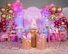 a pink and gold birthday party with balloons, cake and desserts on the table