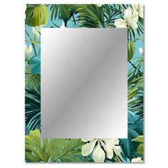 a square mirror with tropical leaves and flowers on the wall in front of a blue background