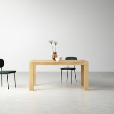 two chairs and a table in an empty room with one chair facing the other way