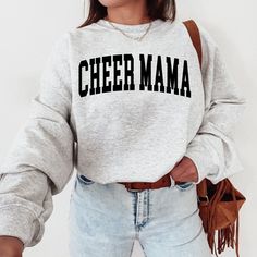 The "Cheer Mama Sweatshirt" is a sturdy and warm sweatshirt bound to keep you warm in the colder months. A pre-shrunk, classic fit sweater made with love for you & your loved ones! Sweatshirt Details: * Gildan sweatshirt - unisex fit * 50% cotton, 50% polyester * Pre-shrunk * Classic fit with no center crease * 1x1 athletic rib knit collar with spandex * Air-jet spun yarn with a soft feel and reduced pilling * Double-needle stitched collar, shoulders, armholes, cuffs, and hem * Model is wearing Team Spirit Long Sleeve Winter Sweatshirt, Gray Sweatshirt For Game Day In Winter, Gray Winter Sweatshirt For Game Day, Sporty Cheerleading Sweatshirt For Winter, Winter Cheerleading Sporty Sweatshirt, Long Sleeve Winter Cheerleading Sweatshirt, Winter Sporty Cheerleading Sweatshirt, Black Long Sleeve Cheerleading Sweatshirt, Winter Team Spirit Fleece Tops