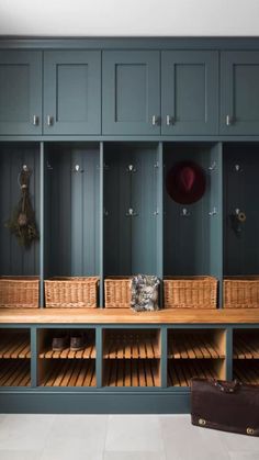 a wooden bench with baskets on it in front of some blue cupboards and shelves