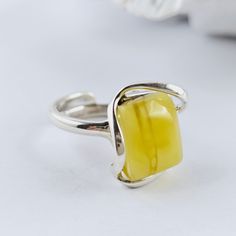 Unique Natural Baltic Amber Ring, White yellow Amber Ring, Amber And Sterling Silver Ring, Baltic Amber Jewelry, Amber Gift For Her, White yellow Amber Amazing adjustable ring made of natural Baltic amber and sterling silver. White Baltic Amber ring. Really stunning, Baltic amber ring in a beautiful white and yellow color. This handmade ring is made of 100% natural, polished Baltic amber and sterling silver. Weight: 7,43 g Dimensions: approx. 1,8 x 1,7 x 1 cm / 0.70 x 0.66 x 0.39 inch Size: adjustable Sterling silver 925 It's a handmade product, each item is unique. Great as a gift. Each of our products is packed in a beautiful gift box. Baltic amber manufacturer and seller from Poland. Our jewelry, beads and other goods shop: https://www.etsy.com/shop/FineBalticJewelry Shipping time to yo Minimalist Yellow Sterling Silver Jewelry, Yellow Citrine Rectangular Rings, Elegant Adjustable Yellow Ring, Yellow Rectangular Citrine Ring, Yellow Adjustable Open Ring Jewelry, Adjustable Yellow Open Ring Jewelry, Minimalist Yellow Jewelry As A Gift, Elegant Yellow Adjustable Ring, Minimalist Yellow Jewelry For Gifts