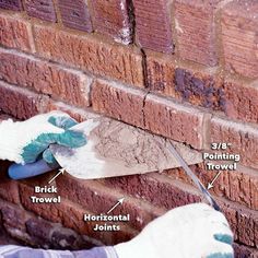 a brick wall is being worked on by someone using a trowel to fix it