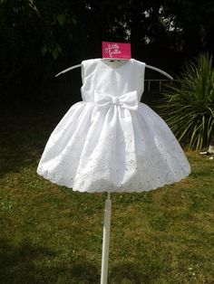 This is an absolutely beautiful Pure White Embroidered Cotton Anglais Baby Dress. It is perfect for baby's First Dress, First Portrait, Baptism or Bridesmaid. The bodice of the dress has a round neck and is sleeveless. It has a lovely White Anglais fabric bow at the centre of the waist. There is a two / three button opening at the back. The skirt of the dress is extremely full and is gathered at the waist. PLEASE NOTE. THIS FABRIC I HAVE NOW IS  EMBROIDERED ANGLAIS BUT NOT A BORDER PRINT I take time and care when making all my baby dresses and each one is made from beautiful fabric and professionally finished. Embroidered Fitted Baptism Dress For Summer, Fitted Embroidered Baptism Dress For Summer, Summer Embroidered Fitted Baptism Dress, White Embroidered Dress For Baptism, Summer Baptism Dress Embroidered, Summer Baptism Dress With Embroidery, Summer Embroidered Baptism Dress, Fitted Embroidered Cotton Baptism Dress, Embroidered Fitted Cotton Baptism Dress