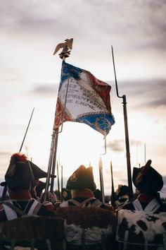 a group of men standing next to each other holding flags