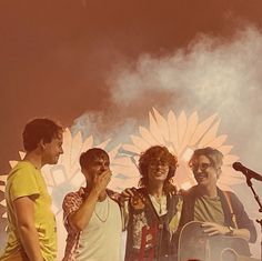 three young men standing next to each other in front of a microphone