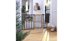 a baby gate in the middle of a room with wood flooring and white walls