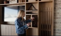 a woman standing in front of a wooden shelf